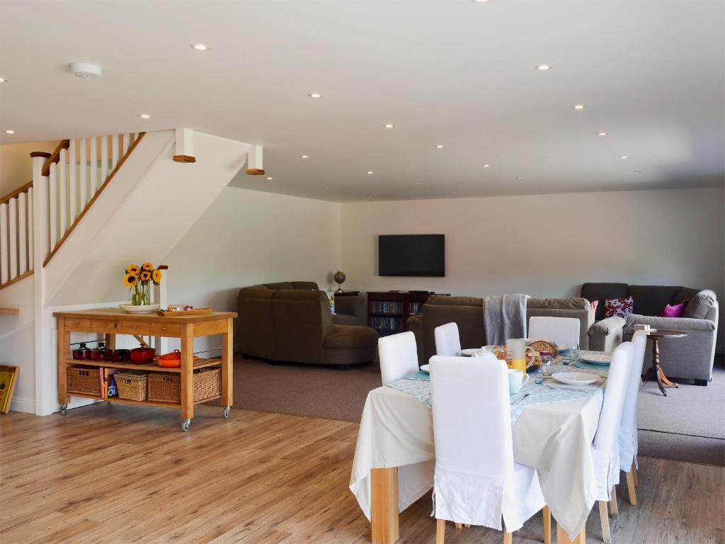 een woonkamer met een tafel en een bank bij Reeds Farmhouse in Bentley