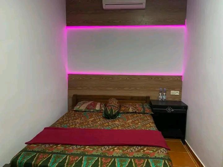 KalakにあるPlatar Ombo Homestayのベッドルーム1室(ピンクの照明付きのベッド1台付)