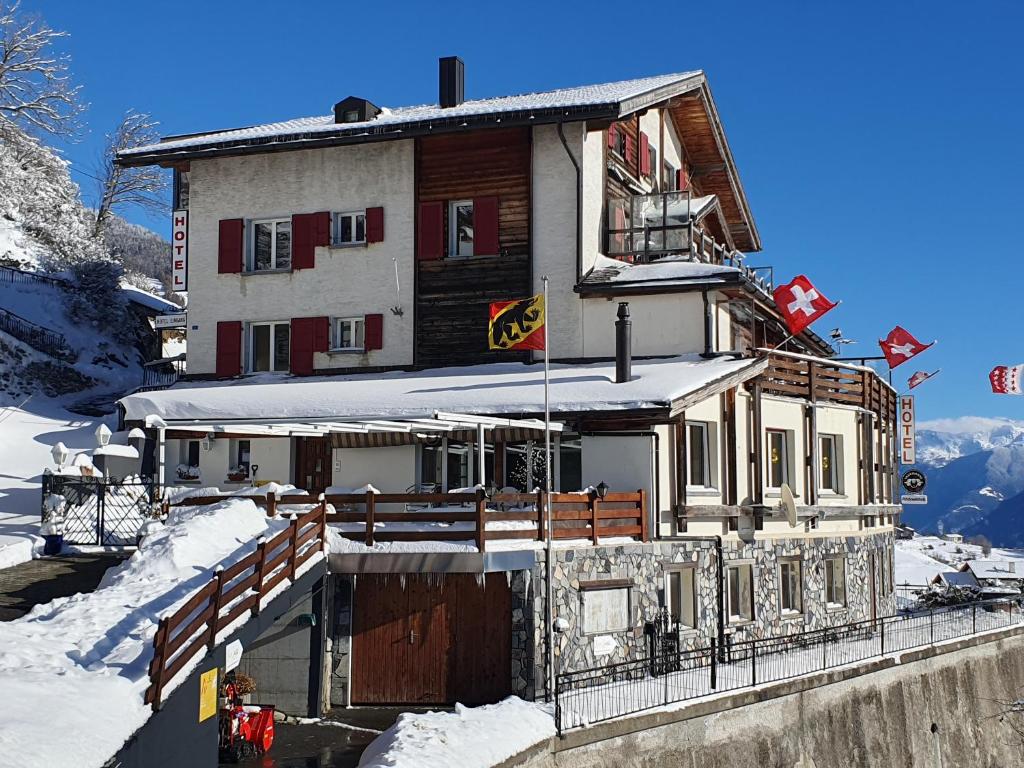 a house in the snow with snow covered at Hotel - Restaurant Rhoneblick in Guttet-Feschel