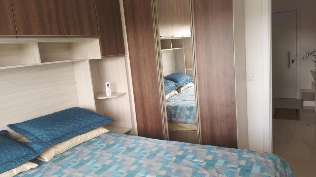 Dormitorio pequeño con cama y armario en Duplex-318 até 8 pessoas, en Florianópolis