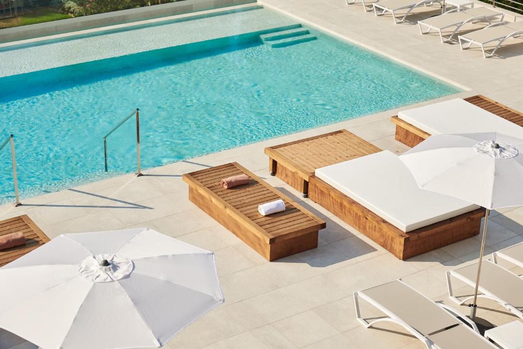 an overhead view of a swimming pool with chairs and umbrellas at DWO Sirius - Adults Only in Santa Susanna