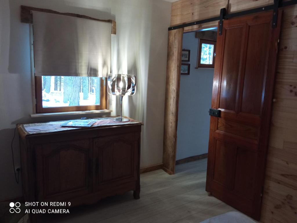 a room with a wooden door and a lamp at Chalet papillon Domaine de la Mamounette in Boussoulet