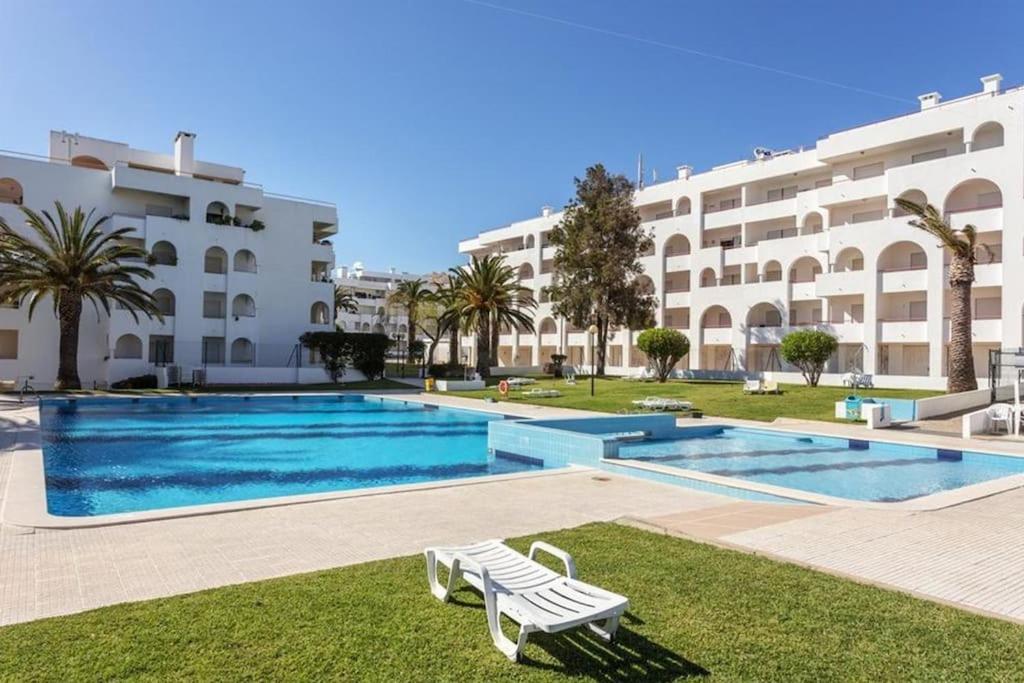 uma piscina em frente a um edifício em PalmBeach House - Qta Palmeiras em Porches