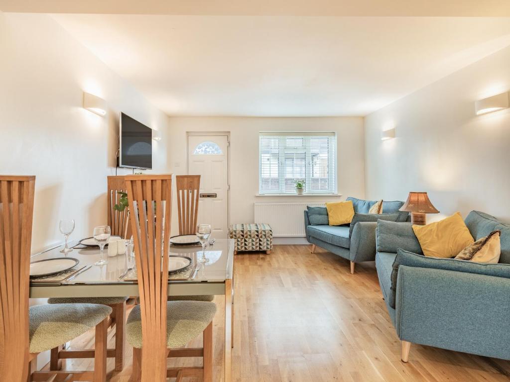 sala de estar con mesa, sillas y sofá en Tea Pot Cottage, en Ringwood