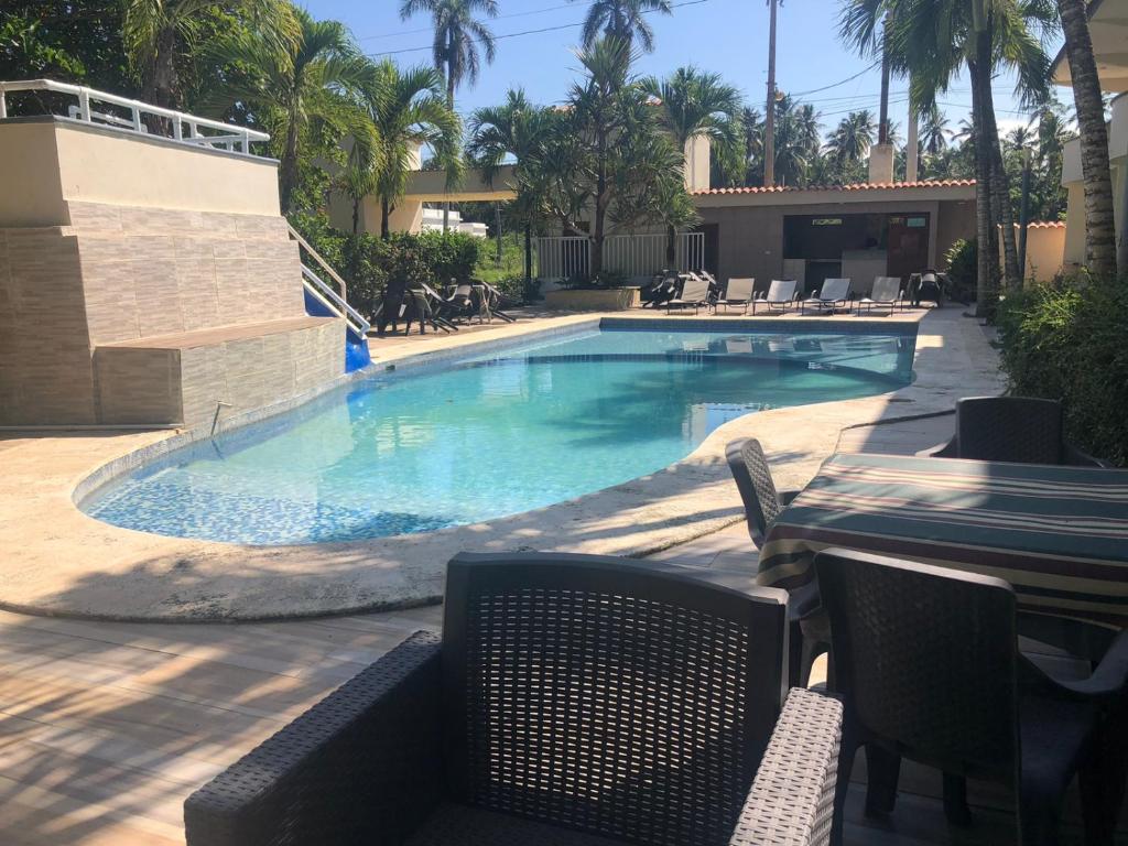 una piscina con mesa y sillas en un complejo en Hotel Cambri, en Nagua