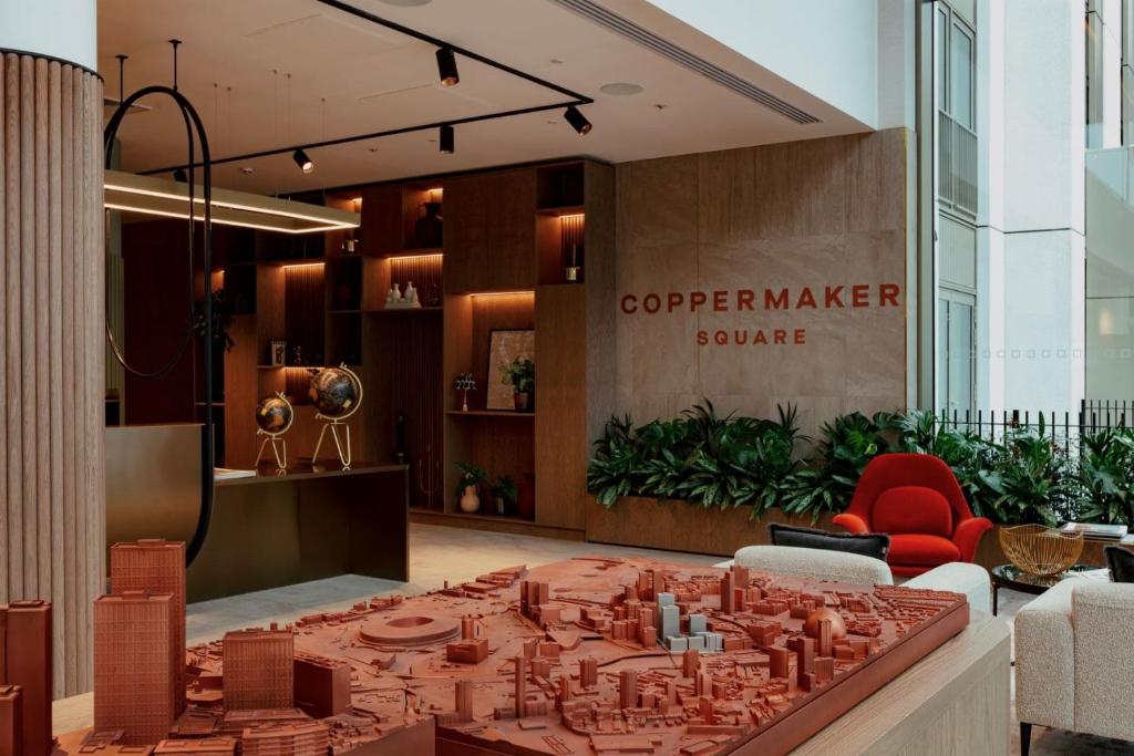 eine Lobby mit einem großen Tisch in der Mitte in der Unterkunft One and Two Bedroom Apartments at Coppermaker Square in Lively Stratford in London