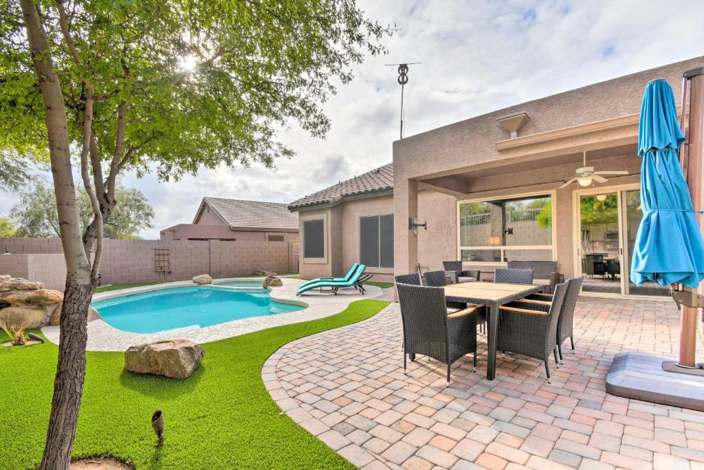a patio with a table and chairs next to a pool at Private Pool and Community Perks Mesa Home! in Mesa