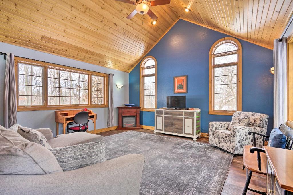 a living room with blue walls and wooden ceilings at Secluded Ellsworth Apartment - Hiking Nearby! 