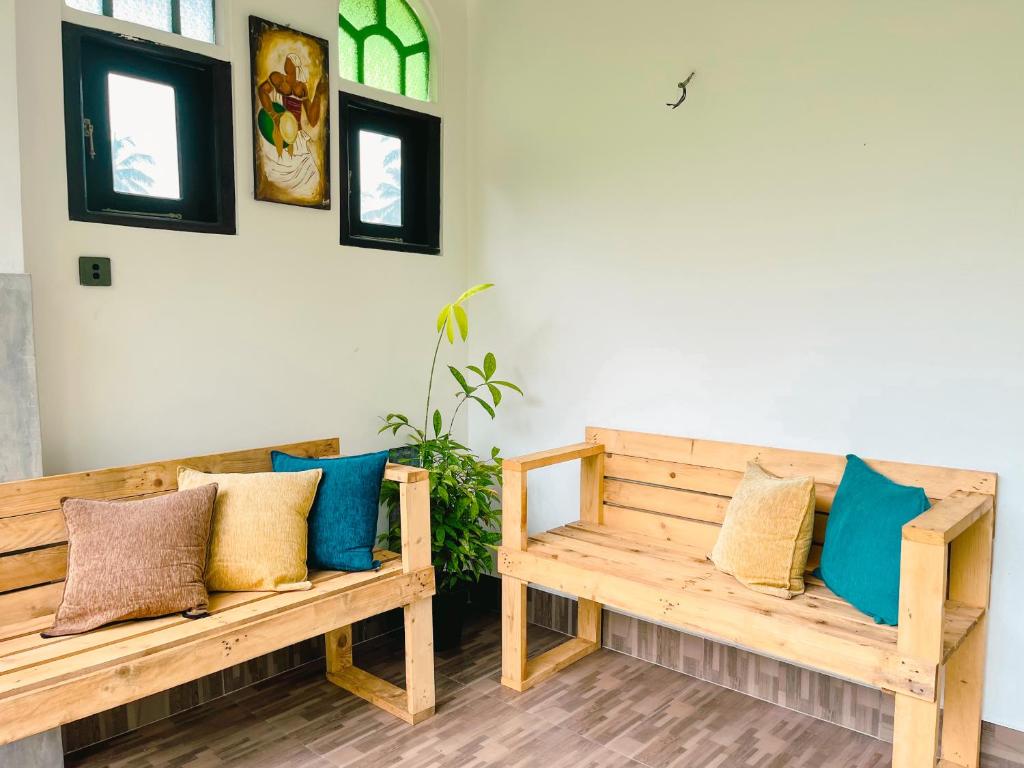 two wooden benches sitting in a room with pillows at Tropical Vibes - Kathaluwa in Ahangama