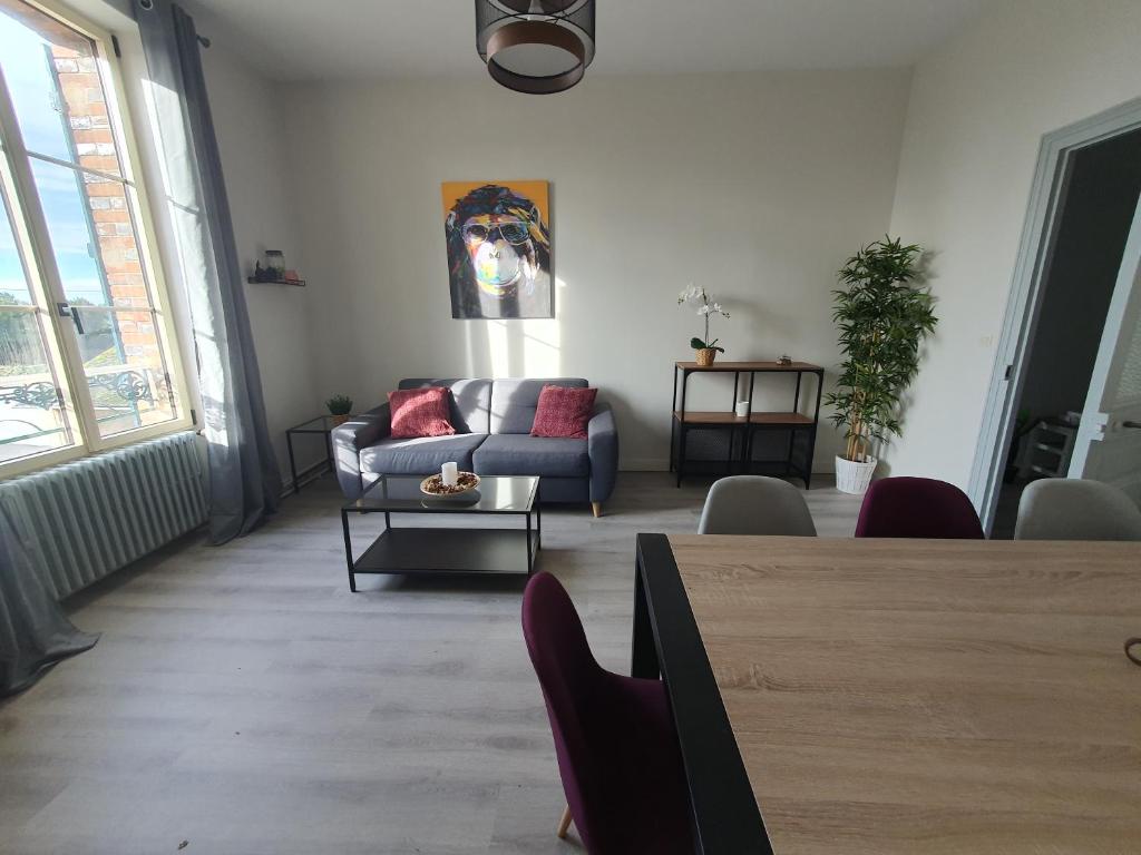 salon z kanapą i stołem w obiekcie Appartement au cœur du village d'Aufferville w mieście Aufferville