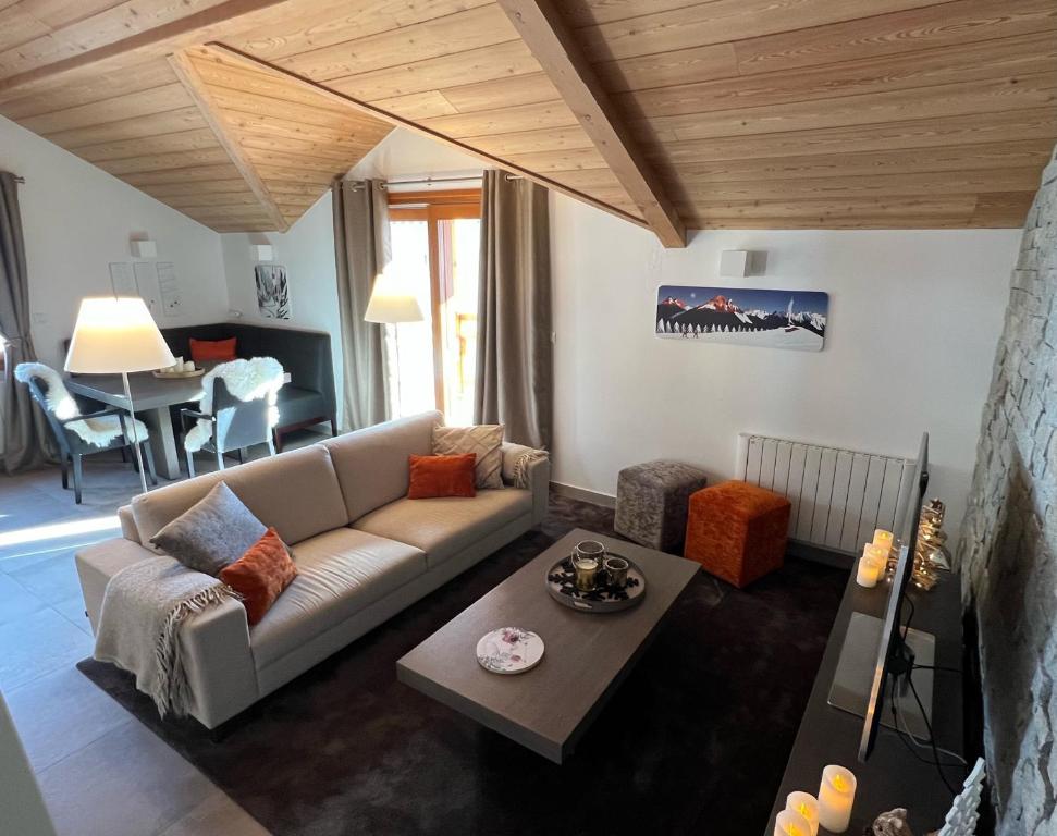 a living room with a couch and a table at Appartement 201, Duplex avec terrasse et garage in Montgenèvre