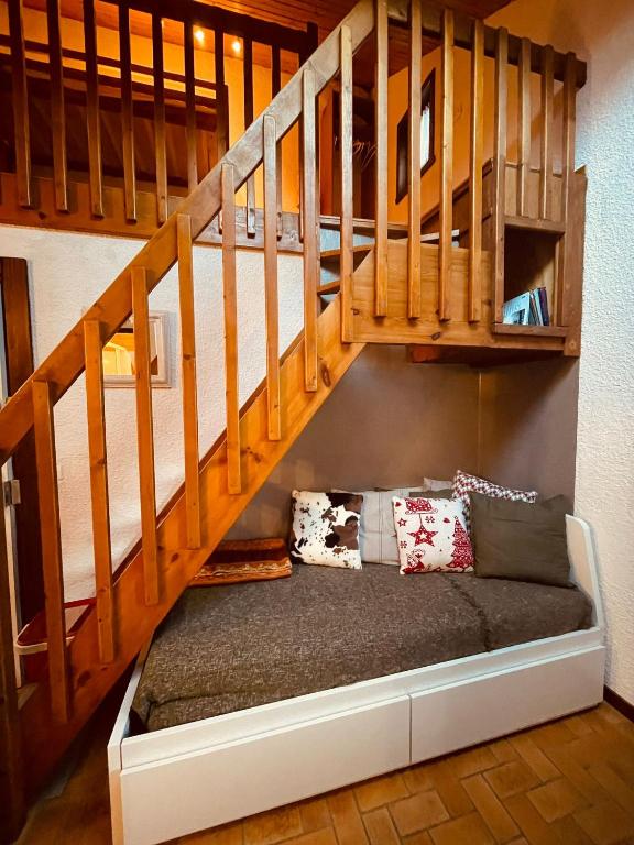 une chambre avec un canapé sous les escaliers dans l'établissement Duplex chaleureux, au Monêtier-les-Bains