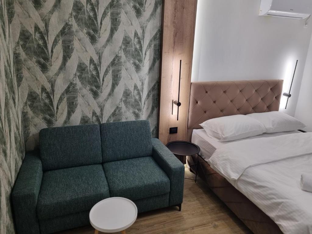 a bedroom with a green couch and a bed at M Lux Apartments in Banja Luka