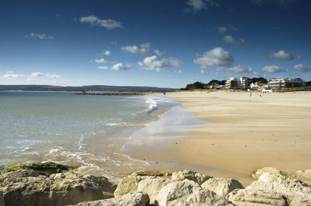 a view of a beach with rocks and the ocean at The Canford in Poole