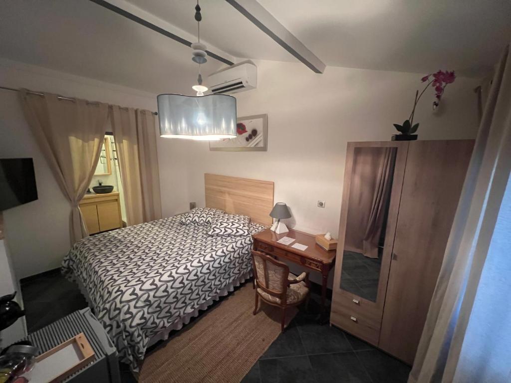 um pequeno quarto com uma cama e uma secretária em Suite parentale indépendante em Marselha