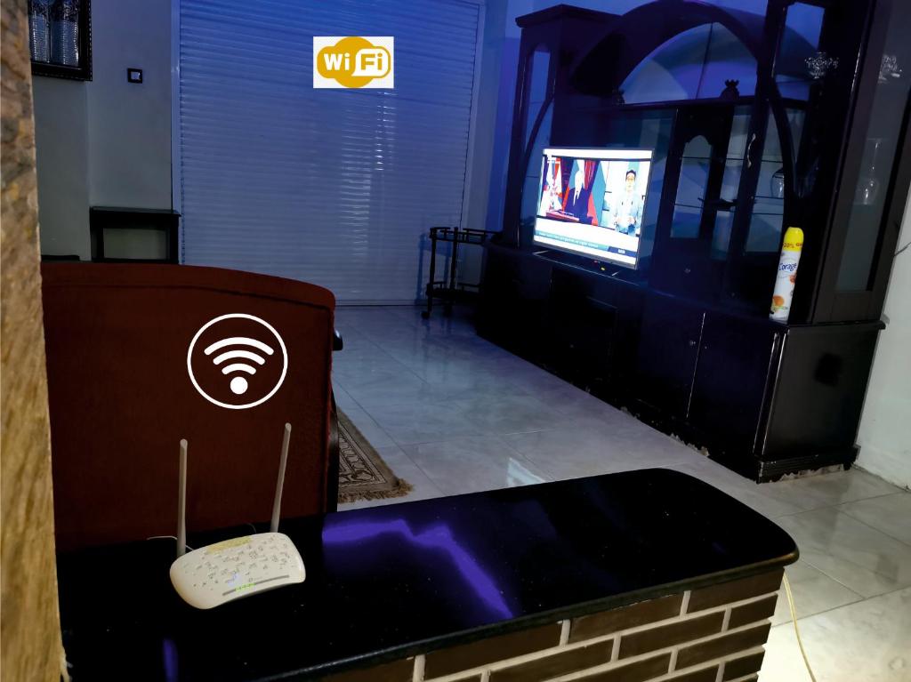 um quarto com uma televisão e uma mesa com controlo remoto em Appartement F4 de Luxe em Constantina