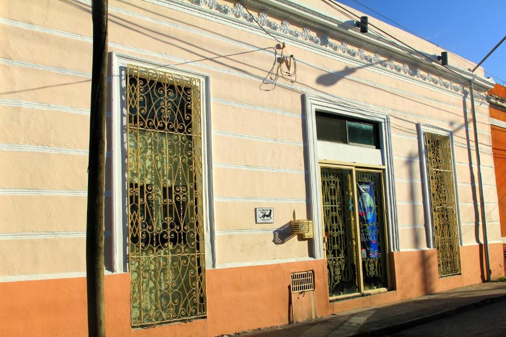 a building with two windows and a door at La Pantera Negra in Mérida