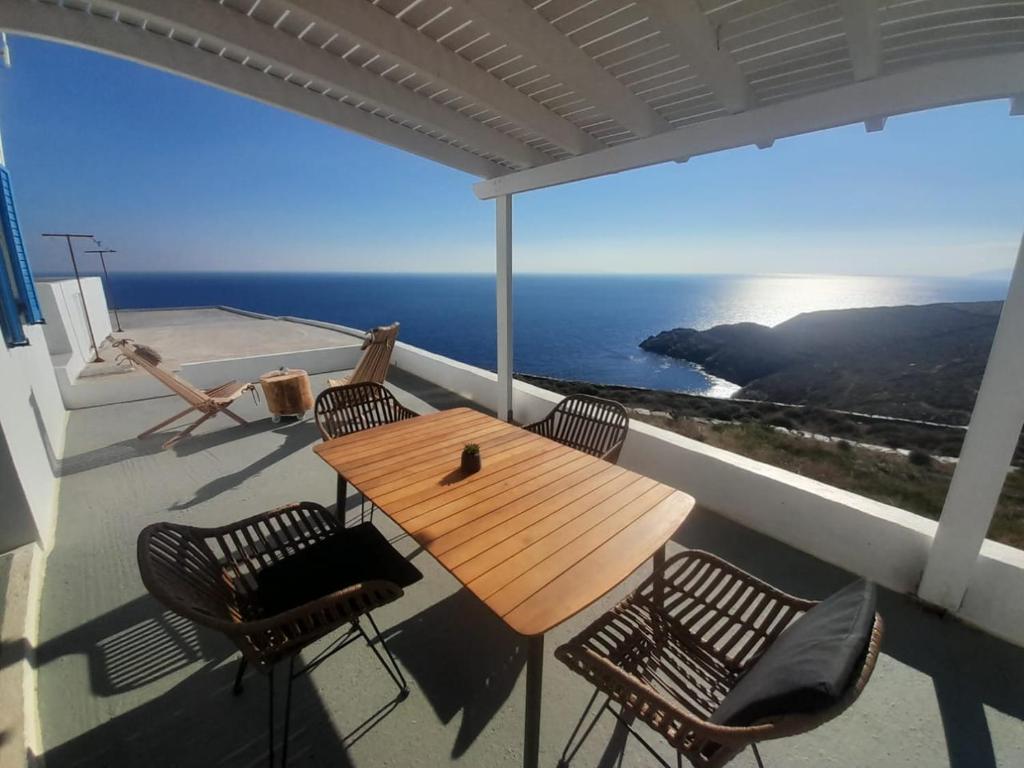 un tavolo e sedie su un balcone con vista sull'oceano di Sofia sea view house a Faros