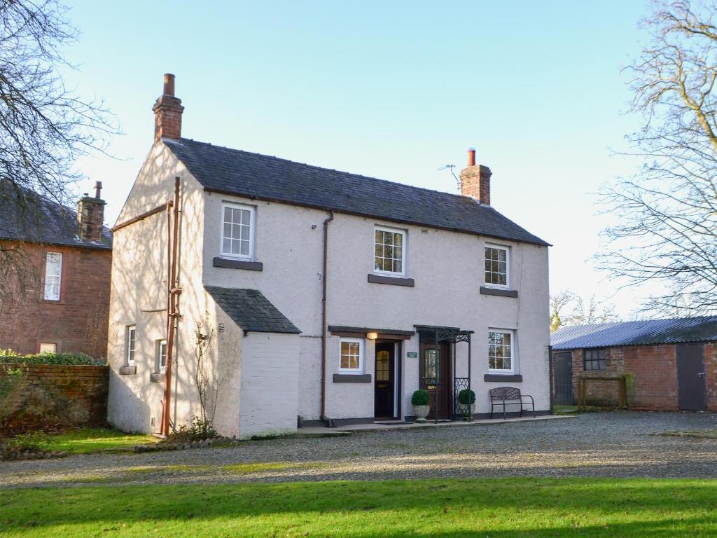 a white house with a black roof at The Coach House in Wetheral