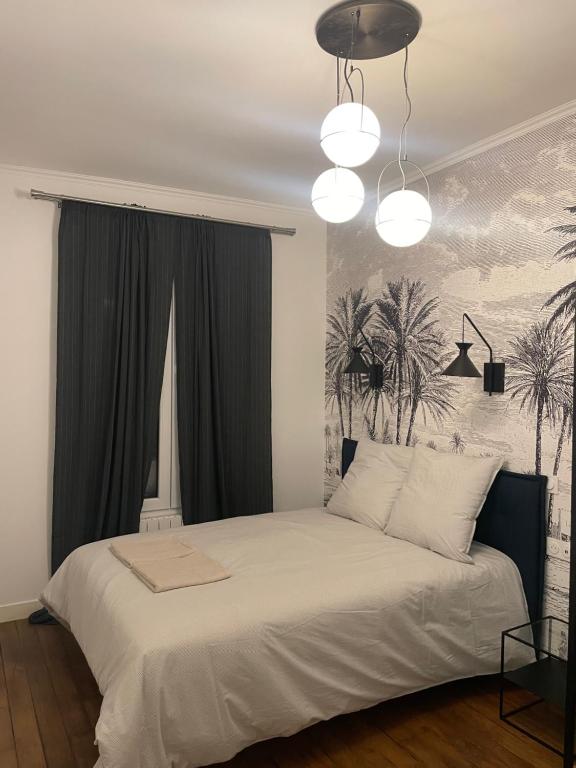 une chambre avec un lit blanc avec un tableau sur le mur dans l'établissement RESIDENCE NATION, à Paris