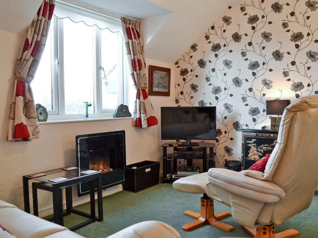 a living room with a fireplace and a tv at Rainbows End in Bowness-on-Windermere