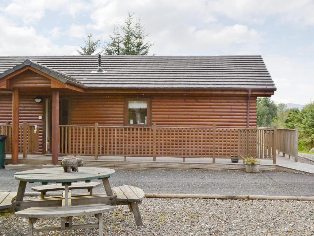 a log cabin with a picnic table in front of it at Glen View in Buchanty