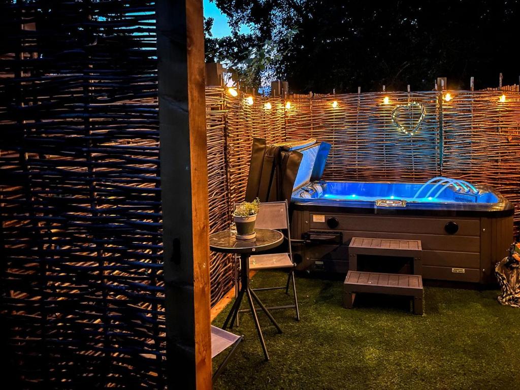 a backyard with a tub and a table and a fence at Peacock On The Pin in Stisted