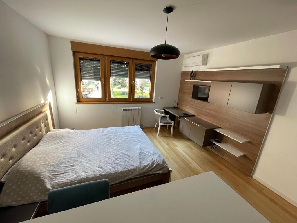 a bedroom with a bed and a desk in it at Apartment Maximus II lux in Novi Beograd