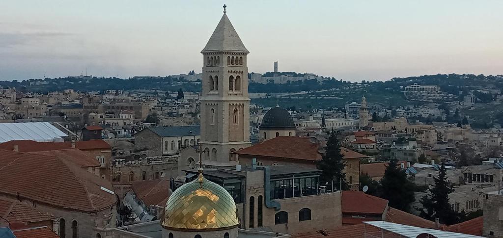 ein großes Gebäude mit einem Uhrturm in einer Stadt in der Unterkunft Jaffa Gate Hostel in Jerusalem