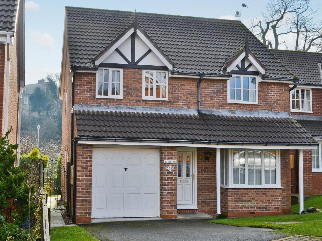 una casa de ladrillo con dos puertas blancas de garaje en Homewood en Alnwick