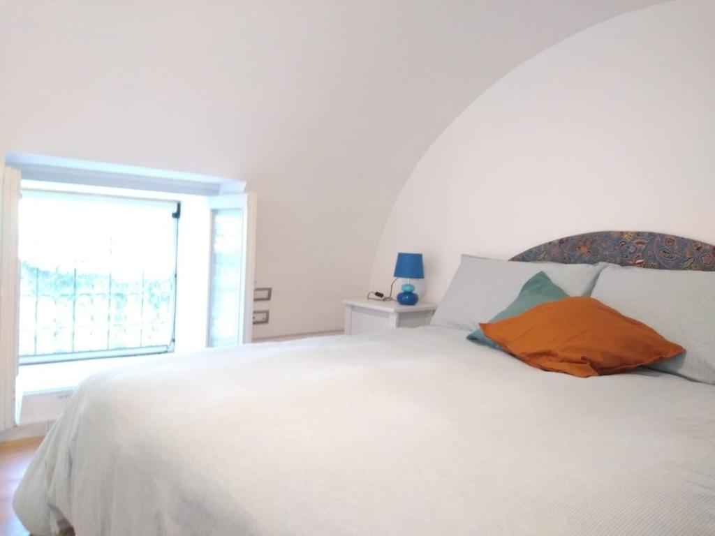um quarto com uma cama branca e uma almofada laranja em TakeAmalfiCoast Minori Center em Minori