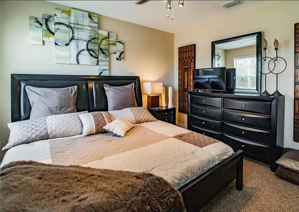 a bedroom with a large bed and a television at 2 King Bed Hot Tub Home in Tampa