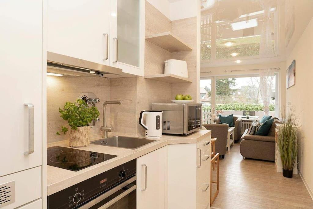 eine Küche mit einer Spüle und einer Mikrowelle in der Unterkunft Moderne Ferienwohnung Grömitz mit Garten/Terrasse in Grömitz