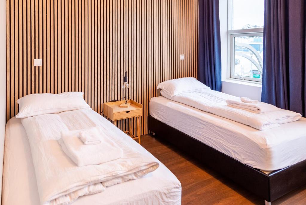 Duas camas num quarto com uma janela em Westman Islands Inn em Vestmannaeyjar