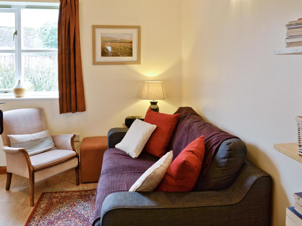 Jasmine Cottage - W41461 في ستورمنستر نيوتن: غرفة معيشة مع أريكة وكرسي