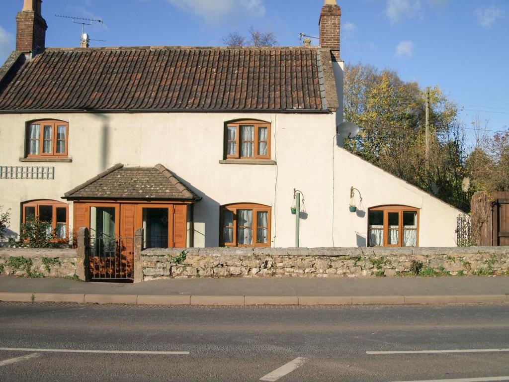 una casa blanca al lado de una calle en The Cottage, en Wells