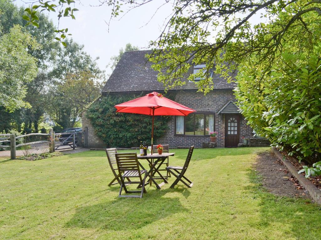 a table and chairs with an umbrella in a yard at Violets in Tonbridge