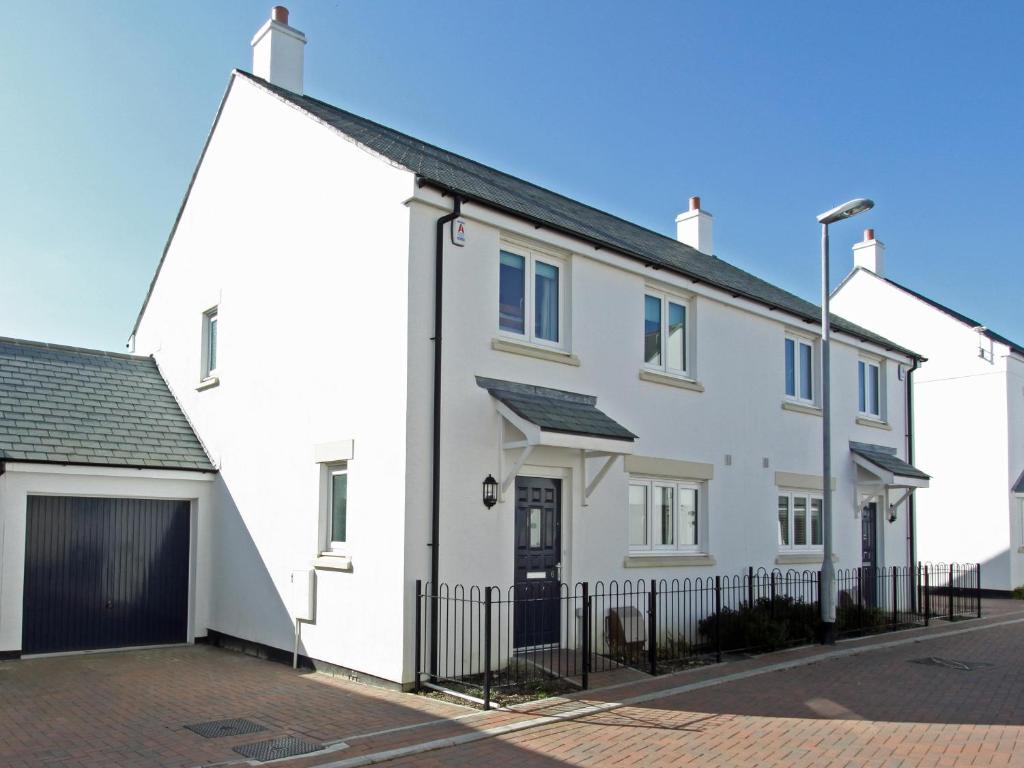 a white house with a black garage at 6 Jubilee Close in Saint Merryn