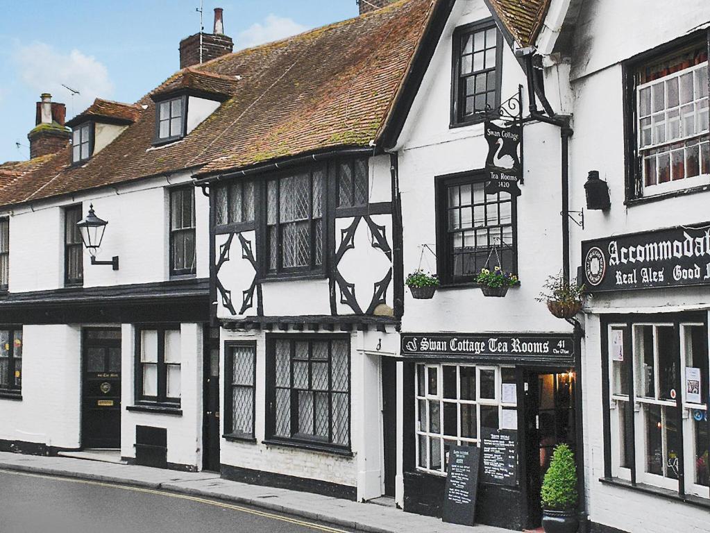 a white building with black windows on a street at The Quarter House in Rye