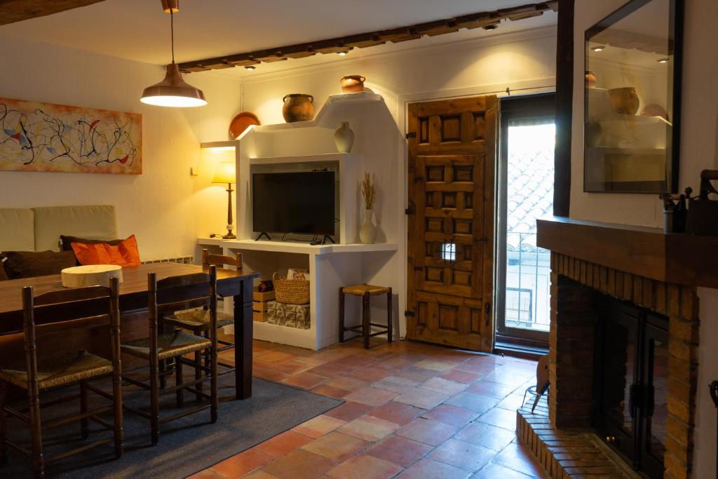 a living room with a fireplace and a dining room at Cuencaloft Casa S-XVII "La Catedral" in Cuenca