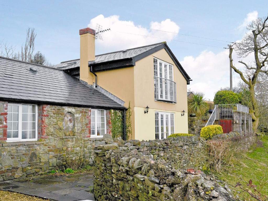 a stone wall in front of a house at Meadow Croft in Llangeinor