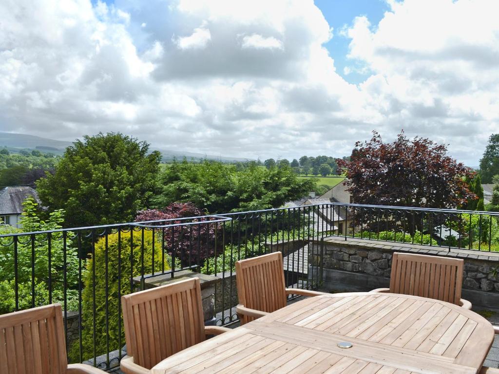 a wooden table and chairs on a balcony at Leyfield Coach House in Kirkby Lonsdale