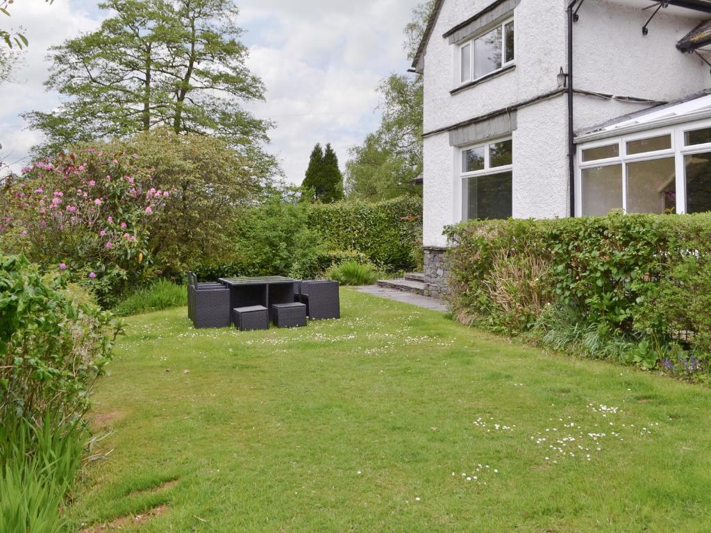 a yard with two black bins in front of a house at Corner Cottage - Lp2 in Windermere