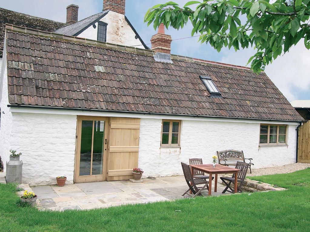 a house with a table and chairs in front of it at The Brewhouse in Foxham