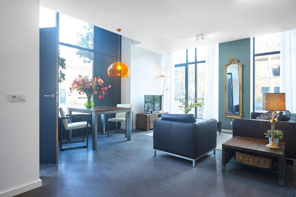 ein Wohnzimmer mit einem Sofa und einem Tisch in der Unterkunft Blush Appartement Centrum Middelburg in Middelburg