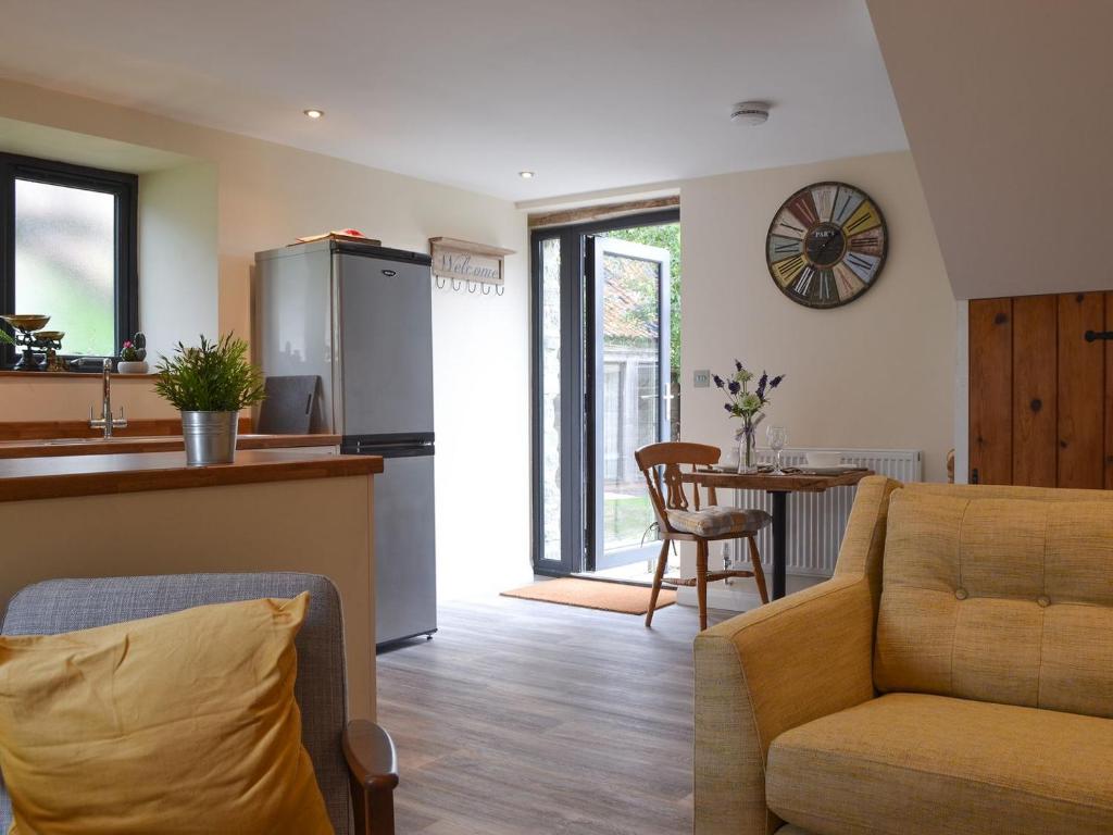 uma cozinha e sala de estar com um sofá e uma mesa em The Stable em Bridgwater