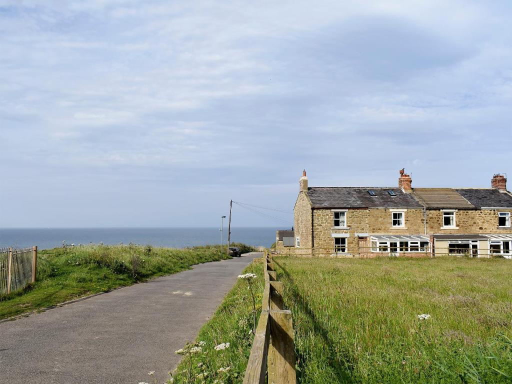 an old house on the side of a road at Sea Breeze Cottage in Staithes