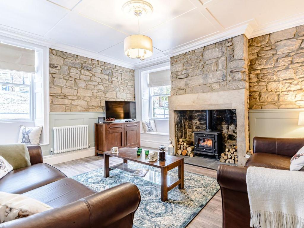 a living room with a couch and a fireplace at Well Strand in Rothbury