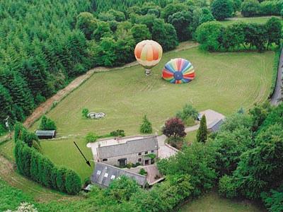 an aerial view of two hot air balloons flying over a house at The Stables Trap Farm in Wolves Newton