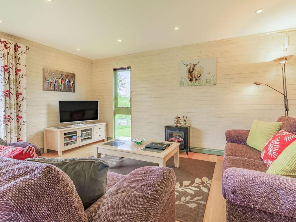 a living room with two couches and a tv at Foxglove Lodge in Holsworthy